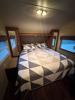 Full-sized bed accessible on both sides with storage closets.