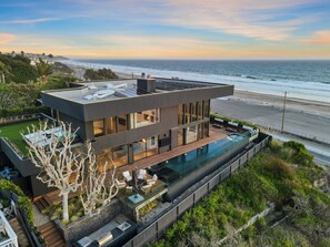 Perched above the shoreline, this sculptural masterpiece invites you into a world of luxury and tranquility.