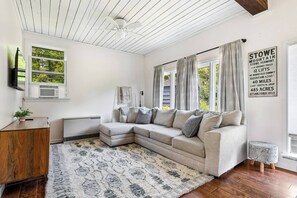 Cozy, light filled living space with TV.
