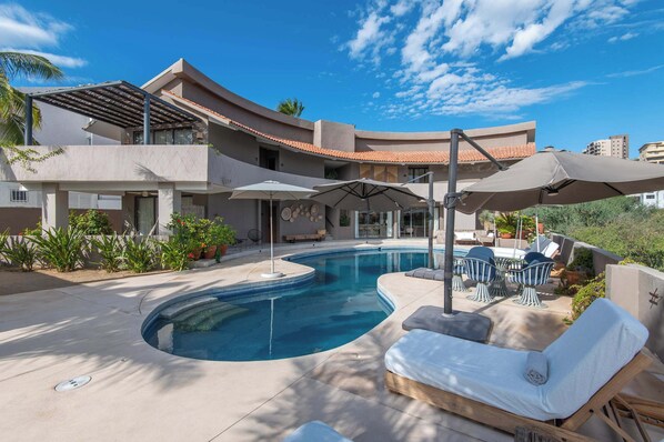 Alberca privada en exterior con camastros 