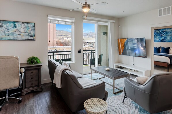 Beautifully designed living room. 65" TV, leather sofa and amazing views of mountains and city skyline.