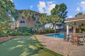 Expansive backyard with a putting green for golf enthusiasts.