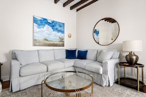Chic corner sofa with modern art and soft lighting.
