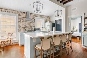 Cook up memories in this fully-equipped chef’s kitchen with a spacious island, bar seating for five, and rustic exposed brick—where vintage charm meets modern convenience.