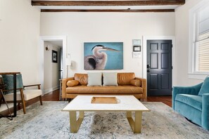 Bright living area with comfy seating and exposed beams.