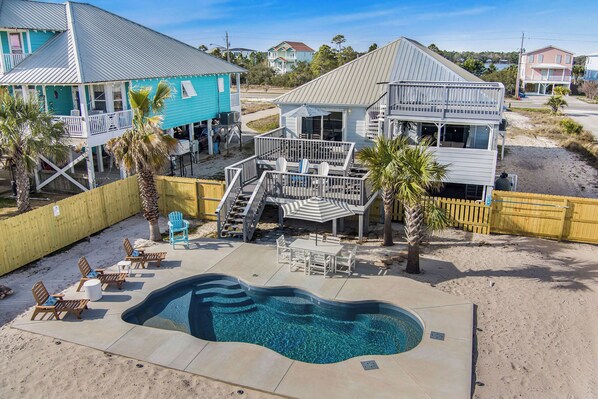 Aerial view of backyard featuring pool with sunbathing ledge & built-in benches