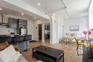 Thoughtfully arranged open space with a lounge area, Smart TV, dining nook, and full kitchen