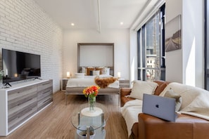 Chic, brick-accented layout with a queen Murphy bed, Smart TV, and natural light throughout