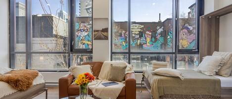 Bright, inviting space with stylish seating and large windows overlooking colourful downtown Montreal murals