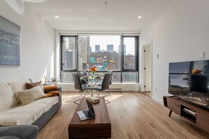 Bright and airy living space with a comfy sofa, smart TV, and window-side dining area
