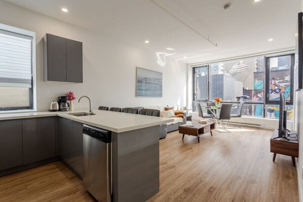 Open-concept layout with modern kitchen, cozy seating, and floor-to-ceiling windows for natural light