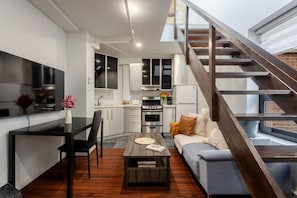 Contemporary setup with smart TV, dining space, and a chic staircase centerpiece