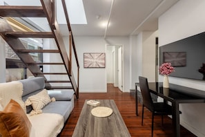 Bright and welcoming with layered textures and open flow to the loft above