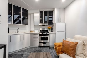 Sleek cabinetry, stainless steel appliances, and cozy accents make this kitchen feel like home