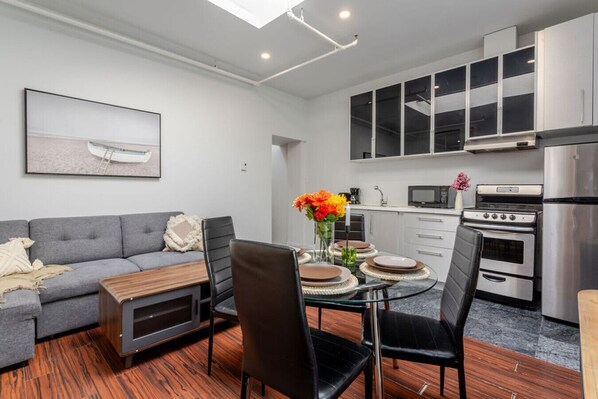 Sleek open layout with a modern kitchen, cozy lounge, and chic dining setup