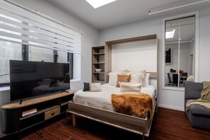 Murphy bed opens to reveal a plush sleeping setup with soft textures and sunlit charm