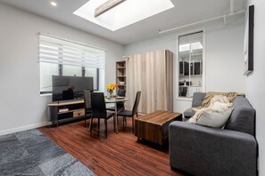 Bright and flexible living space with a Smart HD TV, dining nook, and soft seating