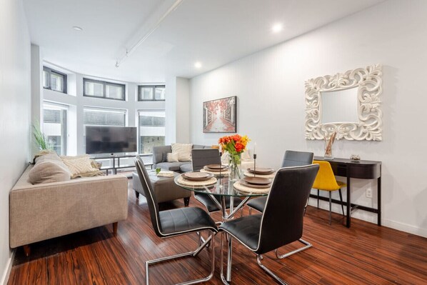 Open-concept living and dining area with bold textures, cozy seating, and statement wall art