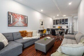Spacious and inviting with a large sectional, warm wood floors, and a modern kitchen flow