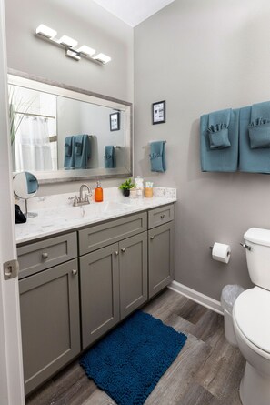 Start your day in style with a spacious vanity, bathroom sink, and lush towels, stocked with bathroom essentials for your ultimate convenience.