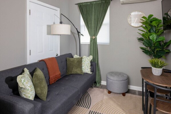 Who doesn’t love a stylish and functional living space? This cozy yet modern living room has it all—a comfy futon bed, a sleek coffee table at the center.