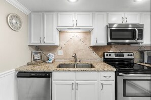 You have ample storage for all your cooking needs surrounded by wonderful warm-toned granite and tile backsplash!