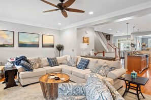 Modern living room with a spacious sectional, ceiling fan, and smart TV