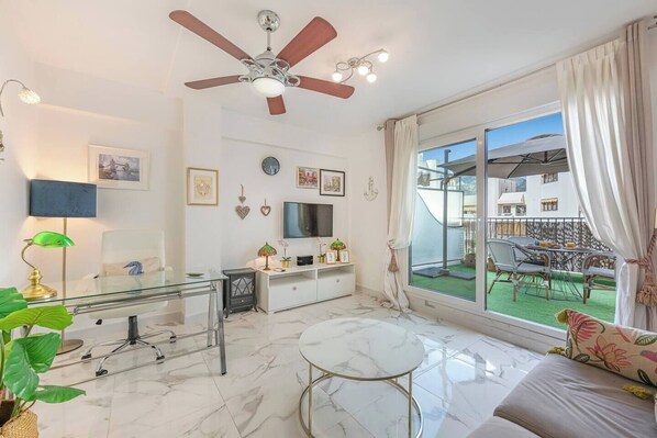 Living Room: Spacious and bright, sofa bed, TV, side table, access to terrace. (1)
