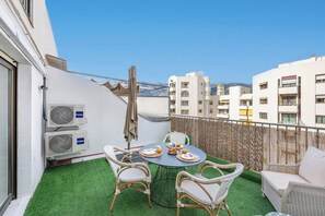 Terrace: Terrace with table, chairs, synthetic grass, and umbrella for outdoor enjoyment. (1)