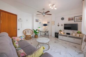 Living Room: Spacious and bright, sofa bed, TV, side table, access to terrace. (2)
