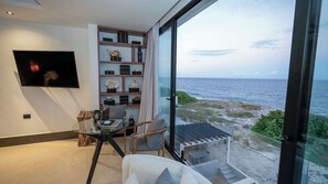 Vista al mar desde habitación, con TV y sillón individual 