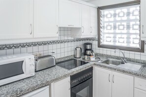 Kitchen space with essential appliances, good for preparing simple meals.