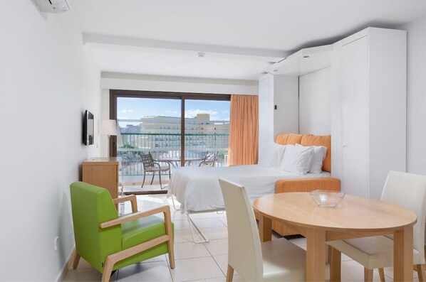 Compact dining and living area with natural light, suitable for meals or studying.