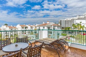 Private balcony with outdoor seating offering panoramic views of the vibrant surroundings.