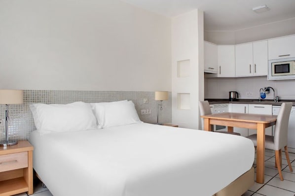 Studio-style room blending sleeping and kitchen areas, designed for convenience and comfort.