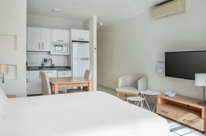 Comfortable bedroom with integrated living space, featuring a large bed and a relaxing lounge area.
