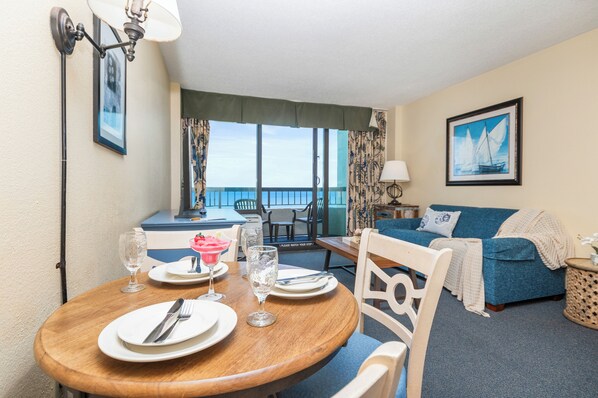 Round dining table elegantly set for four with beach ambiance
