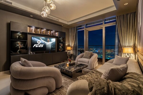 Relax in this stylish, warmly lit living room, featuring modern decor & scenic views that enhance your experience. With a PS5 at your fingertips, enjoy gaming or unwind with a movie. Evenings here are sure to be filled with comfort and entertainment