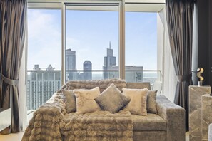 Bright and spacious living room bathed in natural daylight, featuring modern decor, cozy seating, and a welcoming ambiance. A perfect space to relax and enjoy luxury living in the heart of Downtown Dubai.