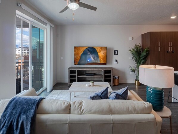 Beautifully designed living room. 75" TV, leather sofa and amazing views of mountains and city skyline.