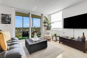 Abundant windows fill the studio with natural lighting; sliding glass doors open to the screened 7th floor balcony.