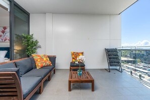 Balcony with table and sofa where you can sit, have your coffee, have some sunlight, and have some fresh air while appreciating the breathtaking view outside.