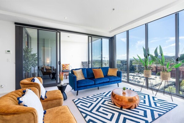 A cosy living room perfect for entertaining friends and family. Feel at ease with our clean and  comfy sofa, soft throws and a combination of happy colors.