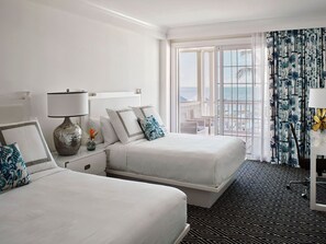 Bright and inviting bedroom with plush beds and vibrant coastal accents, perfect for unwinding.
