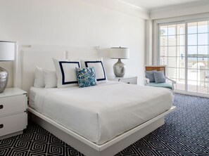 Serene bedroom with plush bedding, soft accents, and a private balcony for a relaxing retreat.