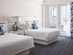 Spacious bedroom with serene tones and floor-to-ceiling windows opening to a private balcony.
