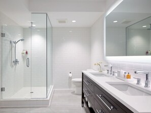 Sleek and modern bathroom featuring a spacious glass shower and elegant dual vanity.