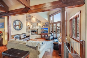 Great Room on main floor with gas fireplace, flatscreen tv, and access to the large decks. - Winter Season