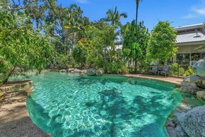 Cool off in the lagoon-style shared pool, surrounded by lush tropical gardens—your private oasis of relaxation and serenity.