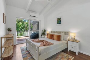 Wake up to a coastal breeze in the primary bedroom upstairs, featuring a queen bed, built-in mirrored wardrobe and direct access to the balcony—perfect for unwinding with a glass of wine before bed.